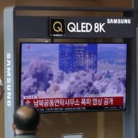 A news program broadcasts the demolition of the inter-Korean liaison office building in Kaesong, North Korea, at the Seoul Railway Station on Wednesday. | AP