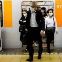 Passengers get off a subway train at Tokyo\'s Shibuya station. More than 60 percent of Japanese workers who have worked from home during the COVID-19 crisis say they want to do so after the pandemic has passed. | REUTERS