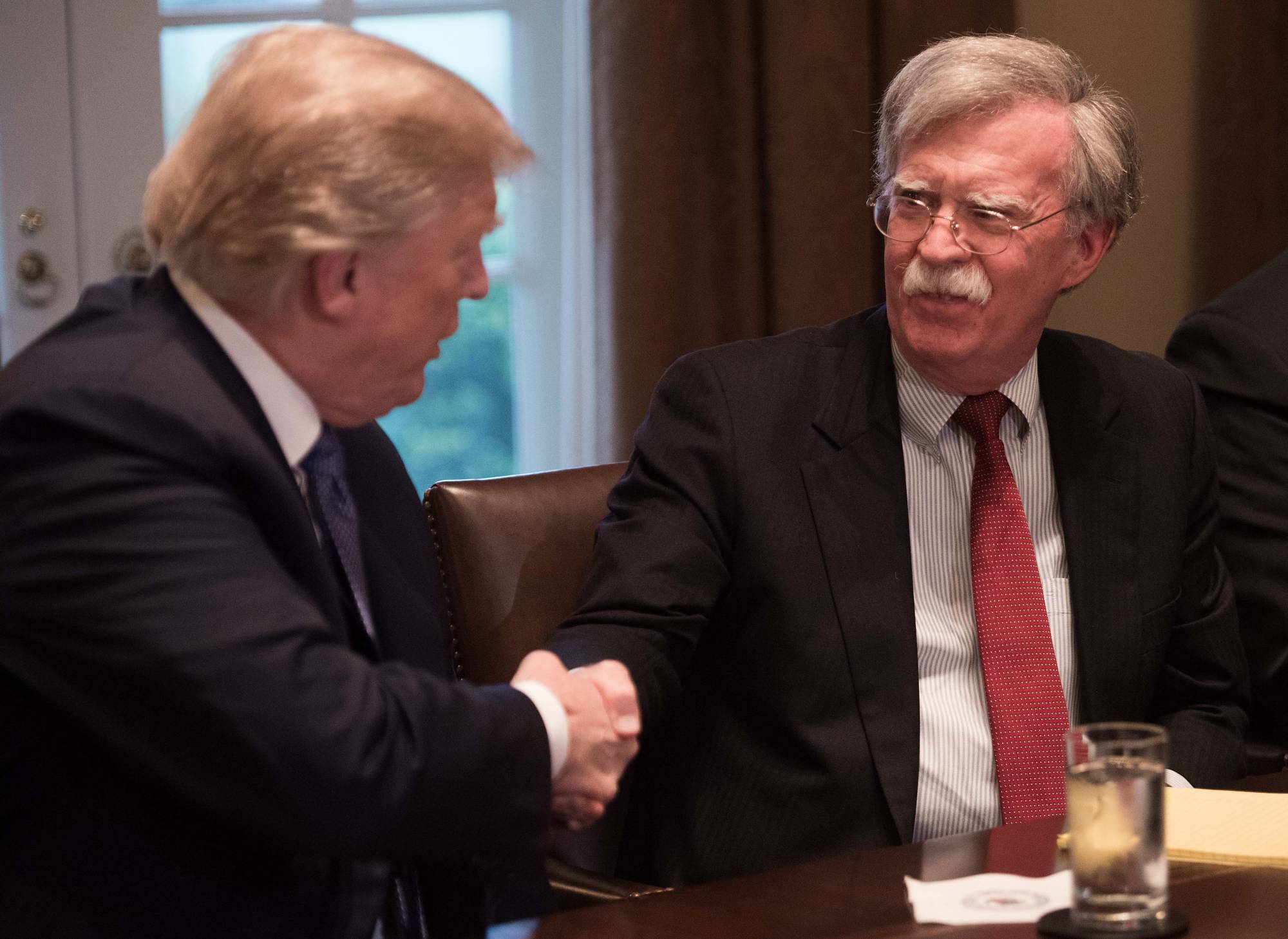 U.S. President Donald Trump greets national security adviser John Bolton at the White House in April 2018. | AFP-JIJI
