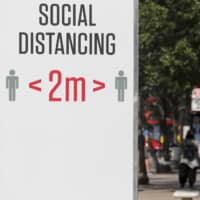 A sign urges 2 meters of social distancing in London on Monday.  | AP