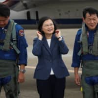 Taiwanese President Tsai Ing-Wen prepares to take photos with the pilots of an AIDC T-5 Brave Eagle, Taiwan\'s first locally manufactured advanced jet trainer, in Taichung on Monday.  | REUTERS 