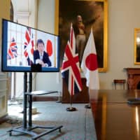 U.K. International Trade Secretary Liz Truss, right, holds a video conference call with Japan\'s Foreign Minister Toshimitsu Motegi as they formally begin negotiations on a free trade agreement at the Department for International Trade in London on June 9. | 10 DOWNING STREET / ANDREW PARSONS / VIA AFP-JIJI