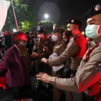 A pro-democracy activist confronts a police officer during a demonstration in Bangkok on Wednesday.  | REUTERS