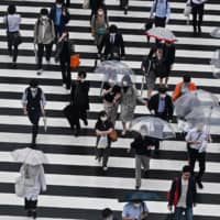 Pedestrians outside Shinjuku Station in Tokyo on Thursday morning | AFP-JIJI 