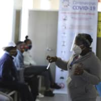 A medical worker addresses vaccine volunteers at a hospital in Soweto, Johannesburg, on Wednesday. | AP
