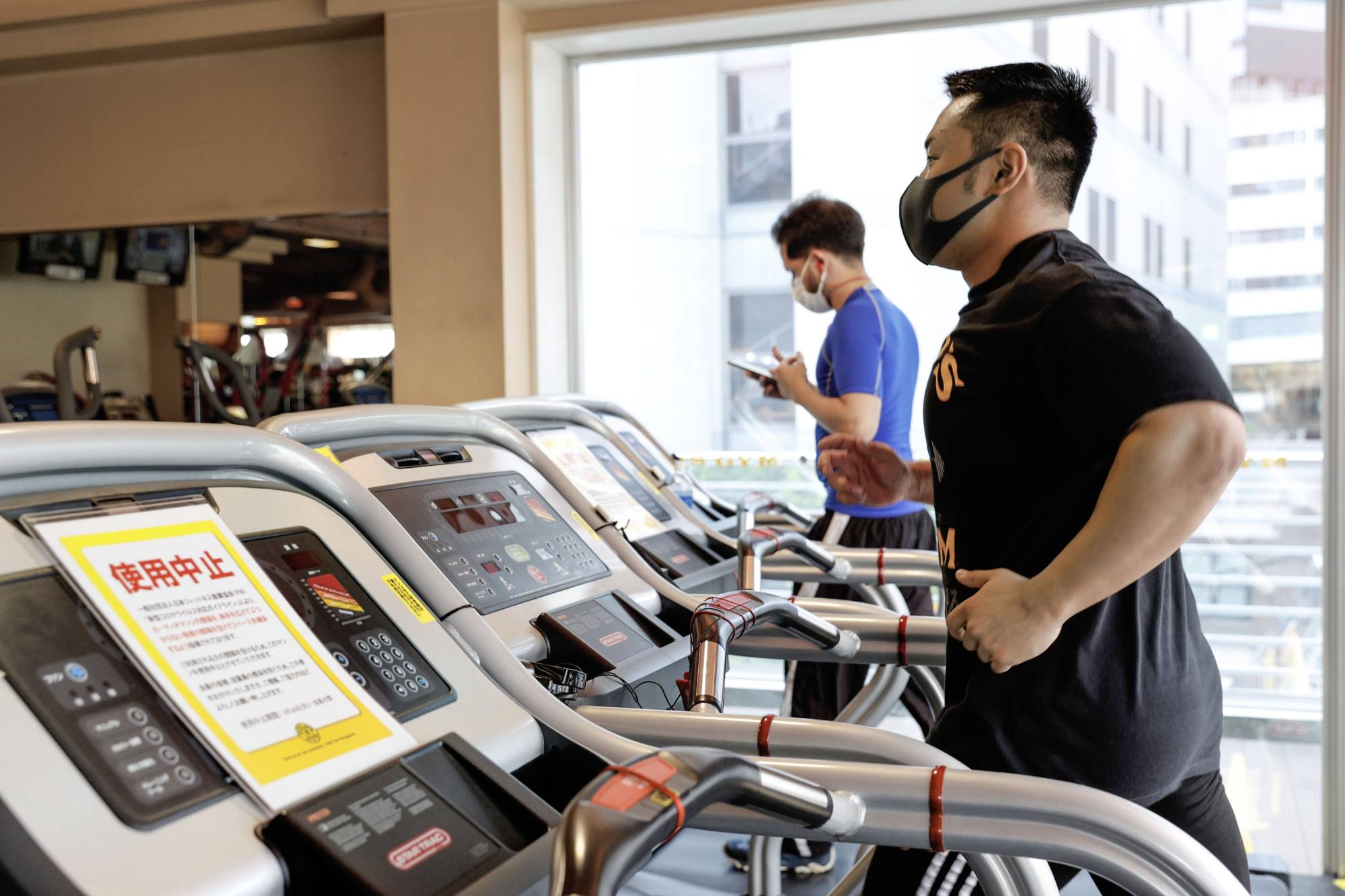 A man uses a running machine at a gym in the city of Osaka on June 1. Some of the machines were idled to maintain social distancing as concerns over the coronavirus linger.  | KYODO