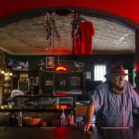 A bar owner in Dallas stores away the liquor supply and closes up for business. Texas Gov. Greg Abbott on Friday took more countermeasures to stem a tide of coronavirus infections, closing bars and ordering restaurants to return to 50 percent capacity.  | THE DALLAS MORNING NEWS / VIA AP