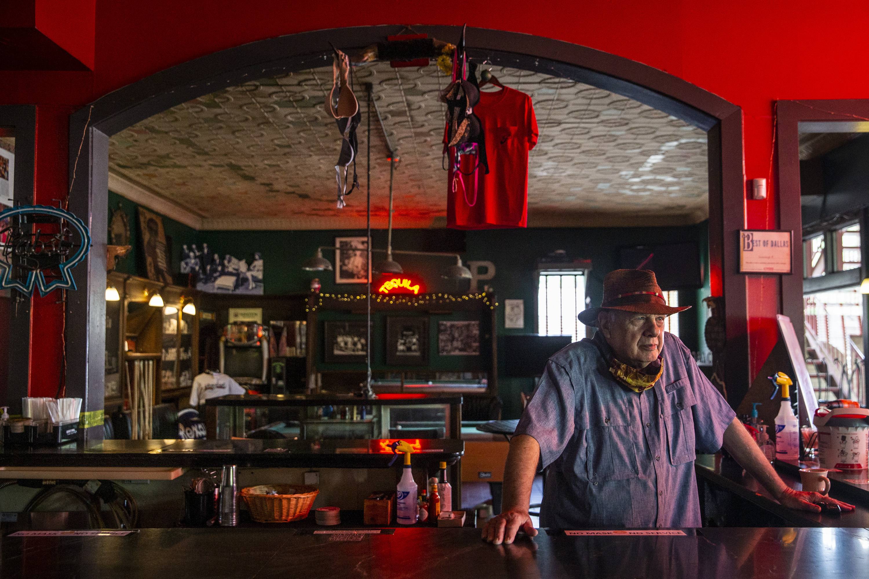 A bar owner in Dallas stores away the liquor supply and closes up for business. Texas Gov. Greg Abbott on Friday took more countermeasures to stem a tide of coronavirus infections, closing bars and ordering restaurants to return to 50 percent capacity. | The Dallas Morning News / via AP