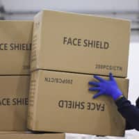 A worker piles up a shipment containing supplies of personal protective equipment to help the southern Italian region of Puglia combat the spread of COVID-19, in Bari, Italy, in April.  | REUTERS 