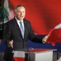 President Andrzej Duda addressees supporters after voting ended in the presidential election in Lowicz, Poland, on Sunday. | AP
