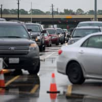 Cars line up at a testing site in Houston on Thursday.  | AFP-JIJI