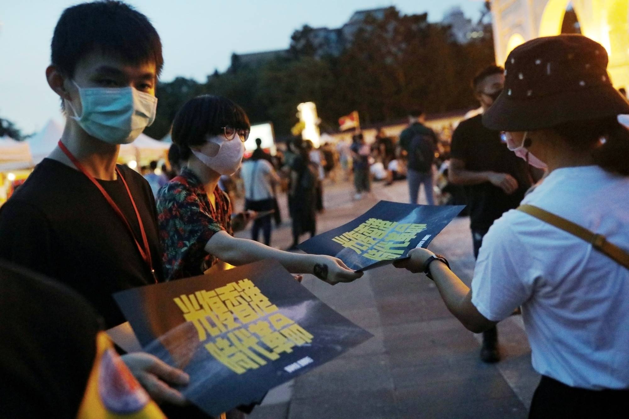 Volunteers hand out posters supporting Hong Kong's anti-government movement in Taipei on June 13. | REUTERS 