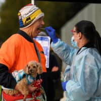 A medical professional administers a test to a member of the public at a pop-up coronavirus testing facility, as the state of Victoria experiences a spike in cases, in Melbourne, Australia, on Friday. 
 | AAP / JAMES ROSS / VIA REUTERS