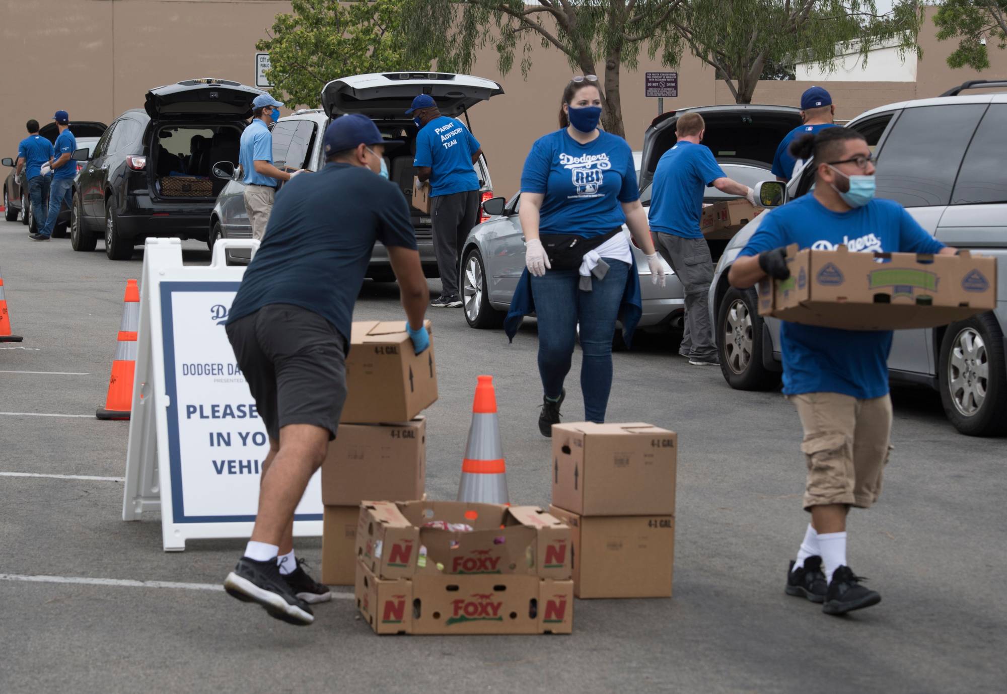 Staff and volunteers with The Los Angeles Dodgers Foundation distribute food and other goods for people facing economic hardship in Huntington Park, California, on June 18. | AFP-JIJI