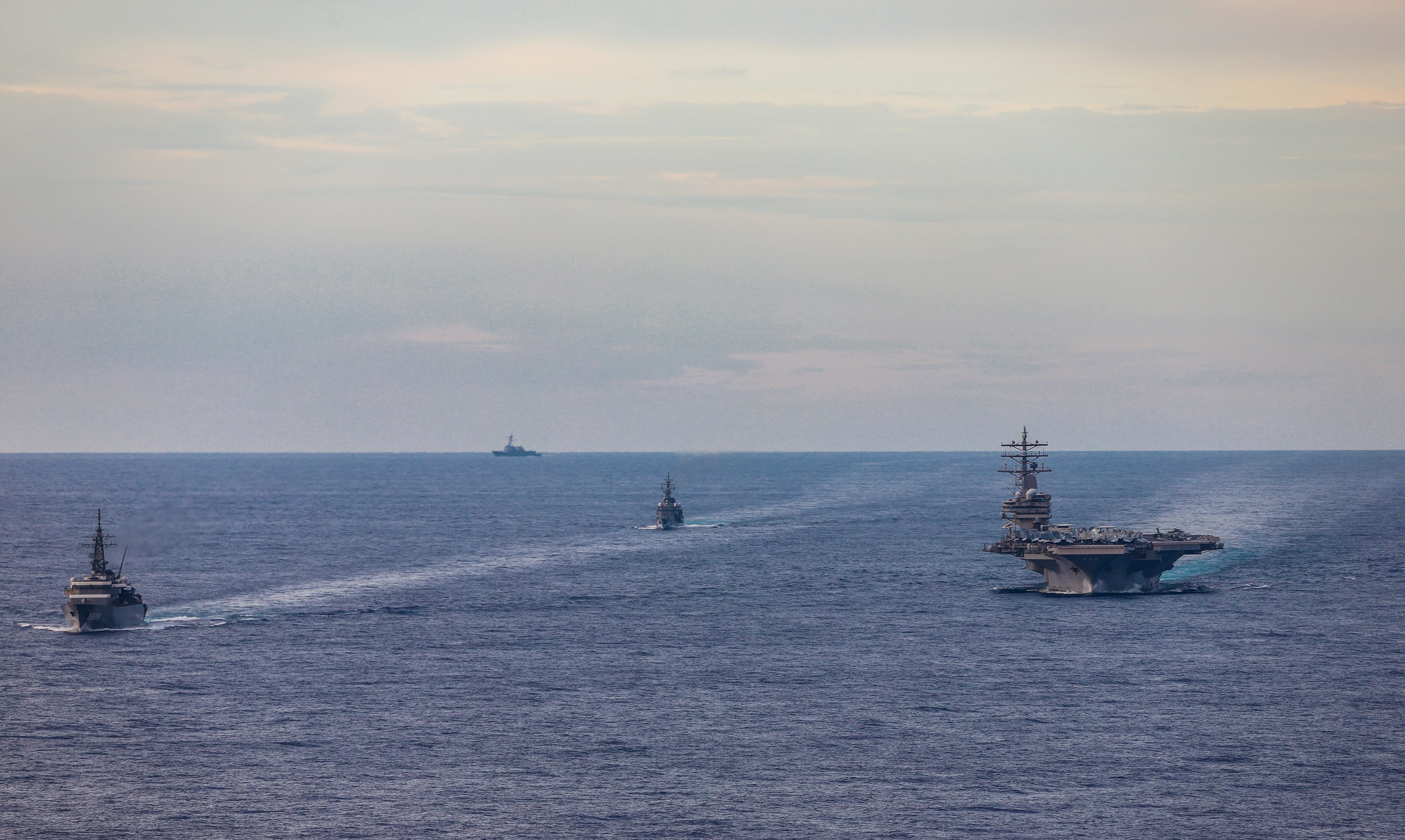 Maritime Self-Defense Force training vessels Kashima and Shimayuki conduct an exercise with the USS Ronald Reagan aircraft carrier in the South China Sea on July 7. | U.S. NAVY / VIA REUTERS