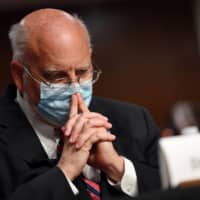 CDC Director Dr. Robert Redfield told a Senate panel that companies need to insist on social distancing and masks. | POOL VIA REUTERS