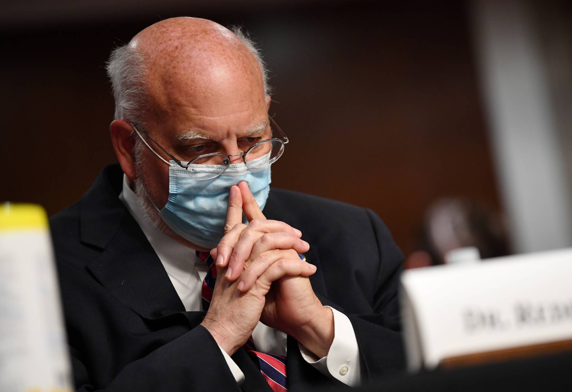 CDC Director Dr. Robert Redfield told a Senate panel that companies need to insist on social distancing and masks. | Pool via REUTERS