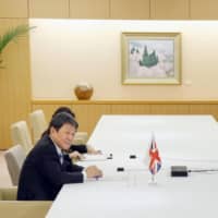 Foreign Minister Toshimitsu Motegi holds a videoconference from Tokyo on June 9 with British trade minister Liz Truss over bilateral trade. | KYODO