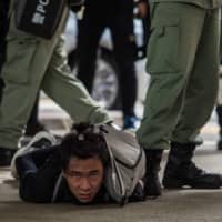 Riot police detain a man as they clear protesters taking part in a rally against a new national security law in Hong Kong on Wednesday. | AFP-JIJI