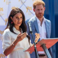 Meghan Markle is watched by Britain\'s Prince Harry as she speaks at the Youth Employment Services Hub in Tembisa township, Johannesburg, in October 2019.  | AFP-JIJI