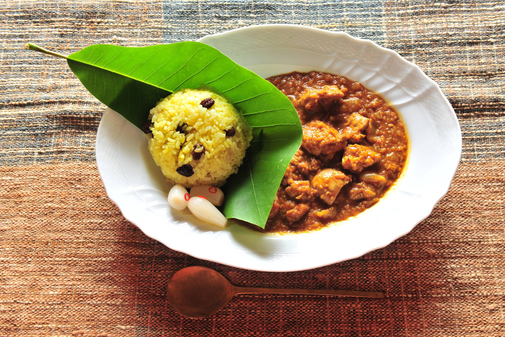 Natural plate: In July, Imamori serves his special 20-spice curry and turmeric rice on the leaf of a Japanese bigleaf magnolia. | Mitsuhiko Imamori