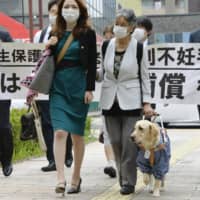 Chieko Muto (right) and her lawyers walk to the Hamamatsu Branch of the Shizuoka District Court to file a lawsuit Friday. | KYODO