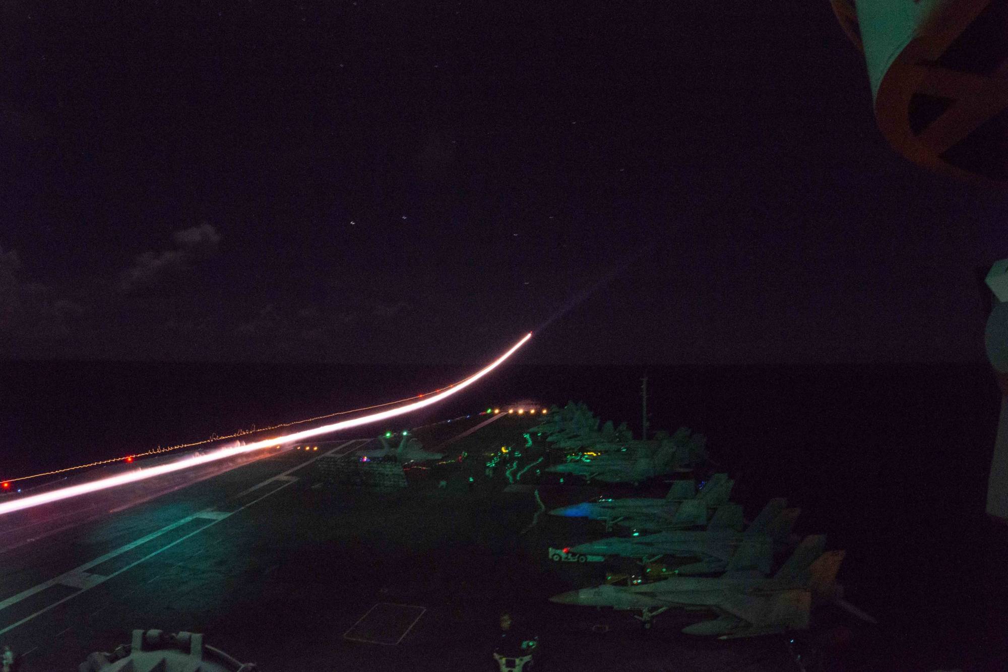 An F/A-18E Super Hornet launches from the flight deck of the USS Ronald Reagan aircraft carrier in the Philippine Sea on Tuesday night. | U.S. NAVY