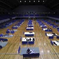 An evacuation center was opened in Hitoyoshi, Kumamoto Prefecture on Saturday. Extra space was left between groups to avoid spreading the coronavirus. | KYODO