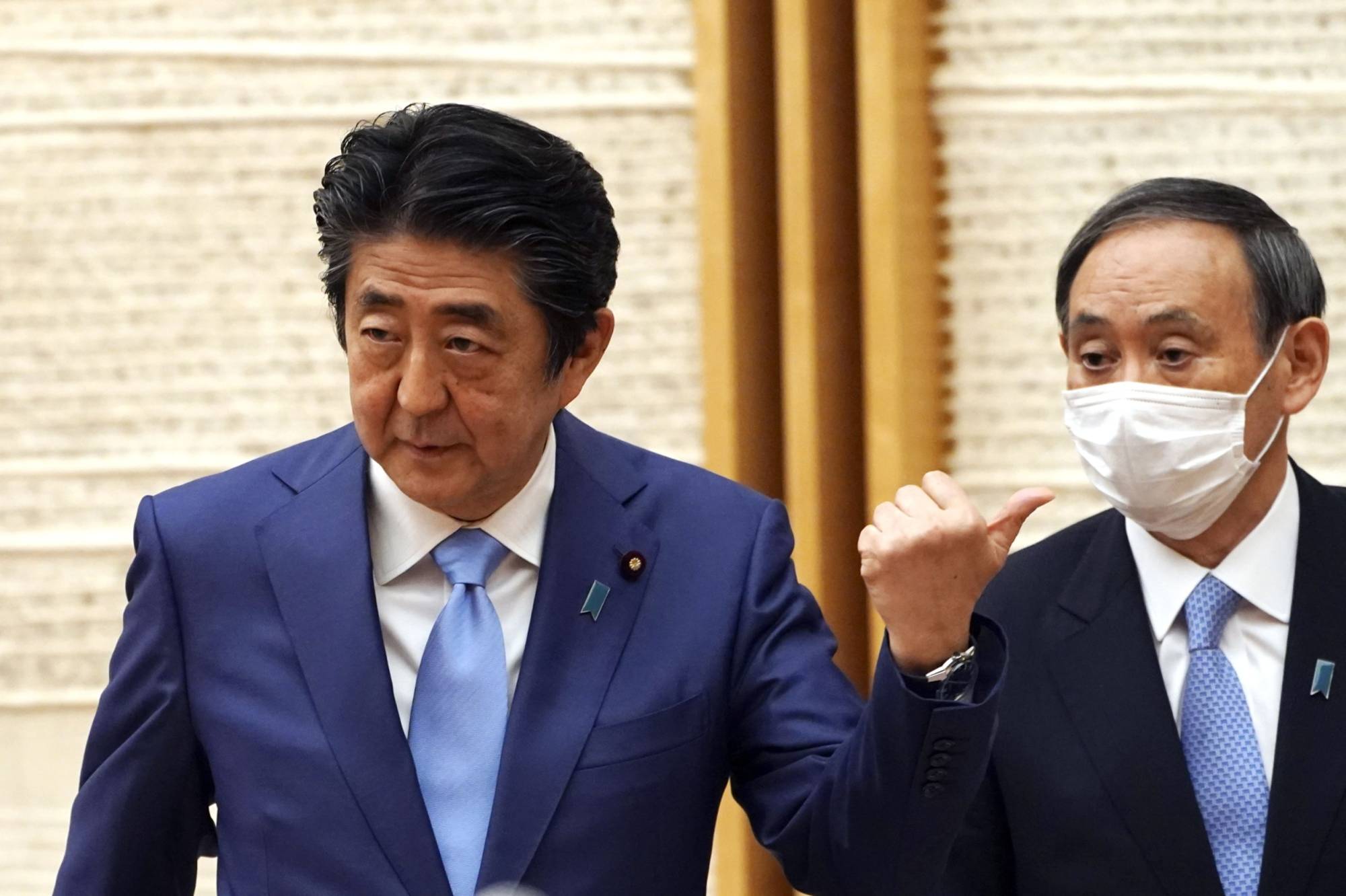 Prime Minister Shinzo Abe (left) and Chief Cabinet Secretary Yoshihide Suga have denied rumors that their long-standing working relationship is on the rocks. | AP / BLOOMBERG