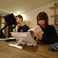 Crystal Pak, right, reads a book in a study room at a share house operated by Be Good Japan Inc. in Tokyo\'s Toshima Ward in March.  | KAZUAKI NAGATA 
