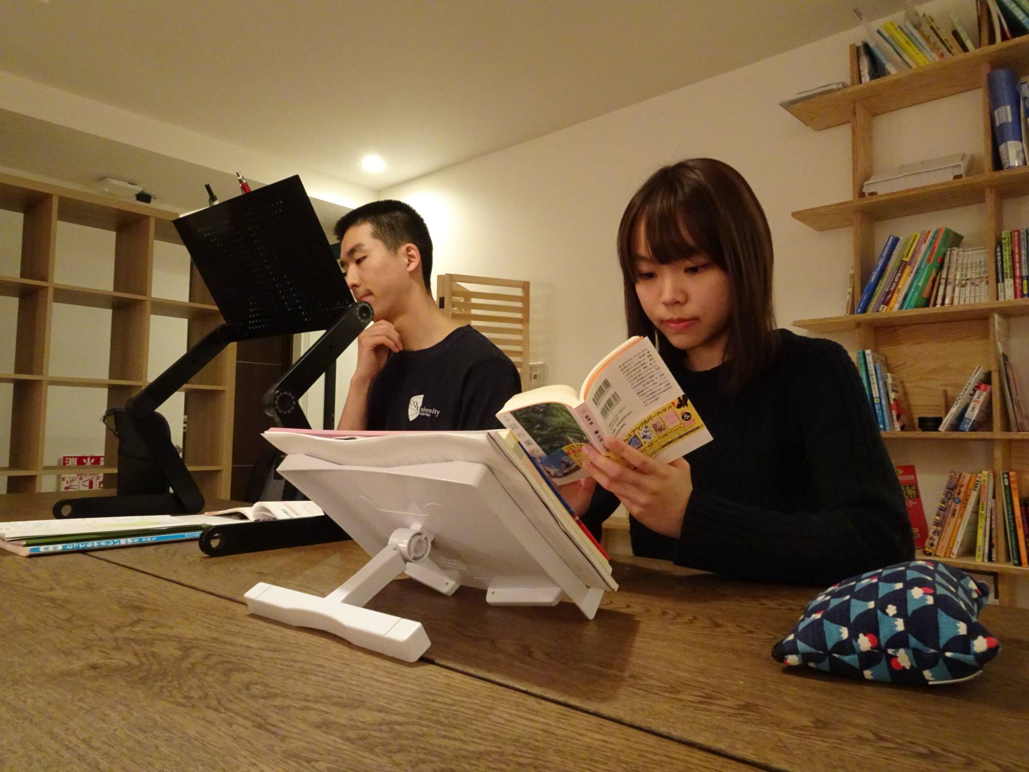 Crystal Pak, right, reads a book in a study room at a share house operated by Be Good Japan Inc. in Tokyo's Toshima Ward in March. | Kazuaki Nagata 