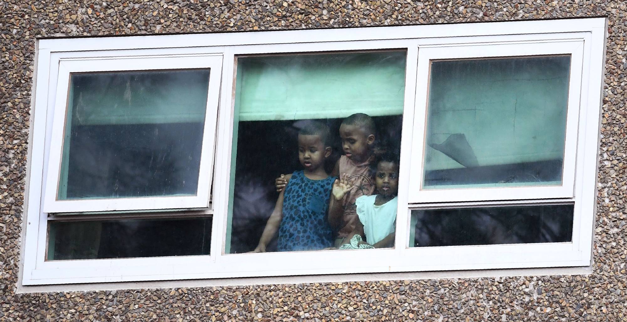 Residents look out from a window Monday at one of nine public housing estates locked down due a spike in COVID-19 cases in Melbourne. | AFP-JIJI