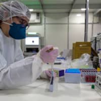 A health worker works with blood samples of COVID-19-infected patients in Sao Paulo on July 1.  | AFP-JIJI