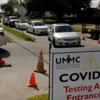 People wait in their vehicles to get tested for COVID-19 in Houston on Tuesday.  | REUTERS