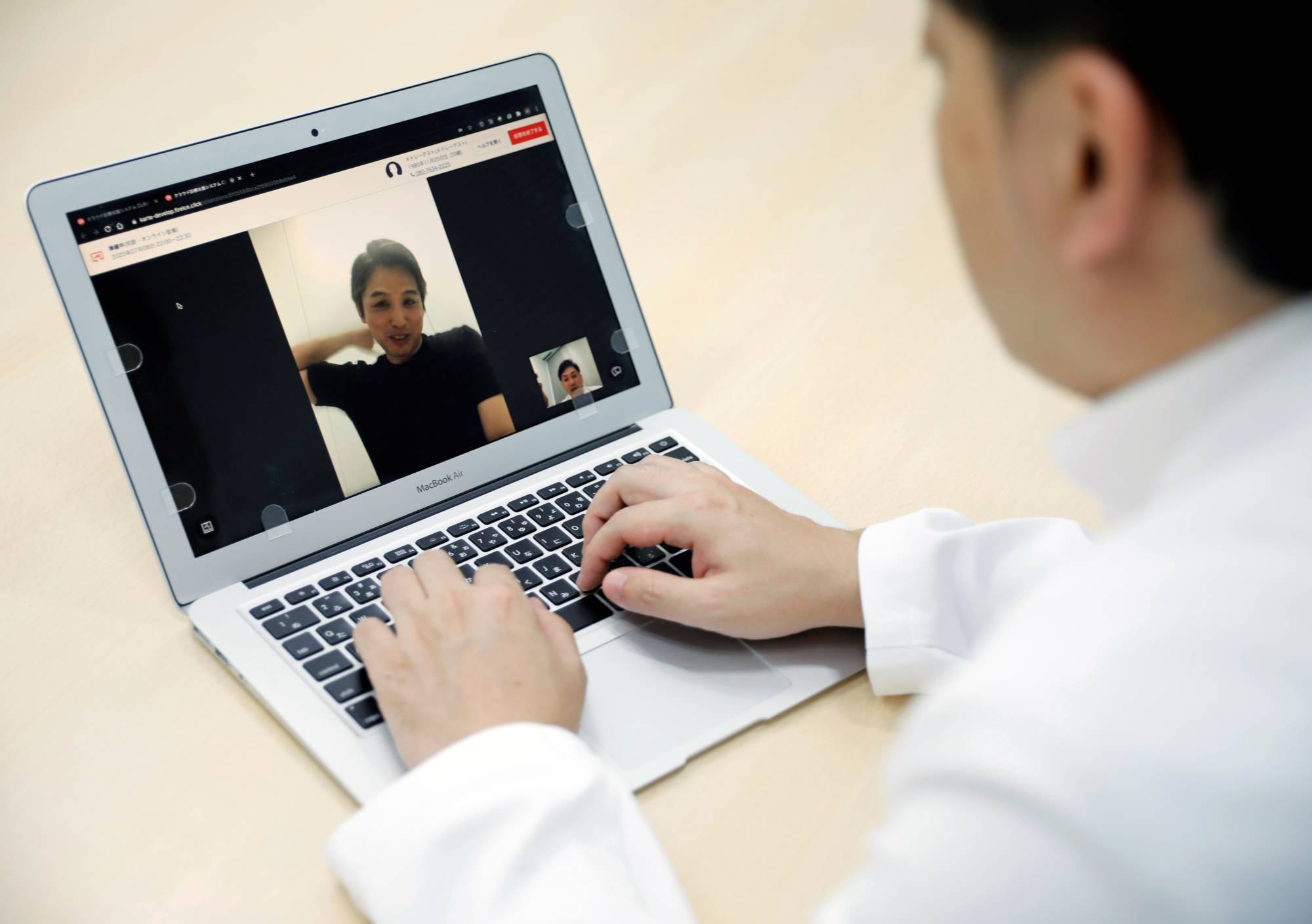 Medical doctor Makoto Kitada demonstrates a telemedicine application service called 'CLINICS', developed by medical start-up Medley Inc., in Tokyo on Wednesday. | REUTERS
