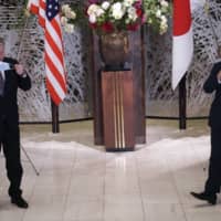 U.S. Special Representative for North Korea Stephen Biegun, left, and Vice Foreign Minister Takeo Akiba, right, take off their protective masks for a photo session prior to their bilateral meeting at Iikura Guest House on Thursday in Tokyo. | AP