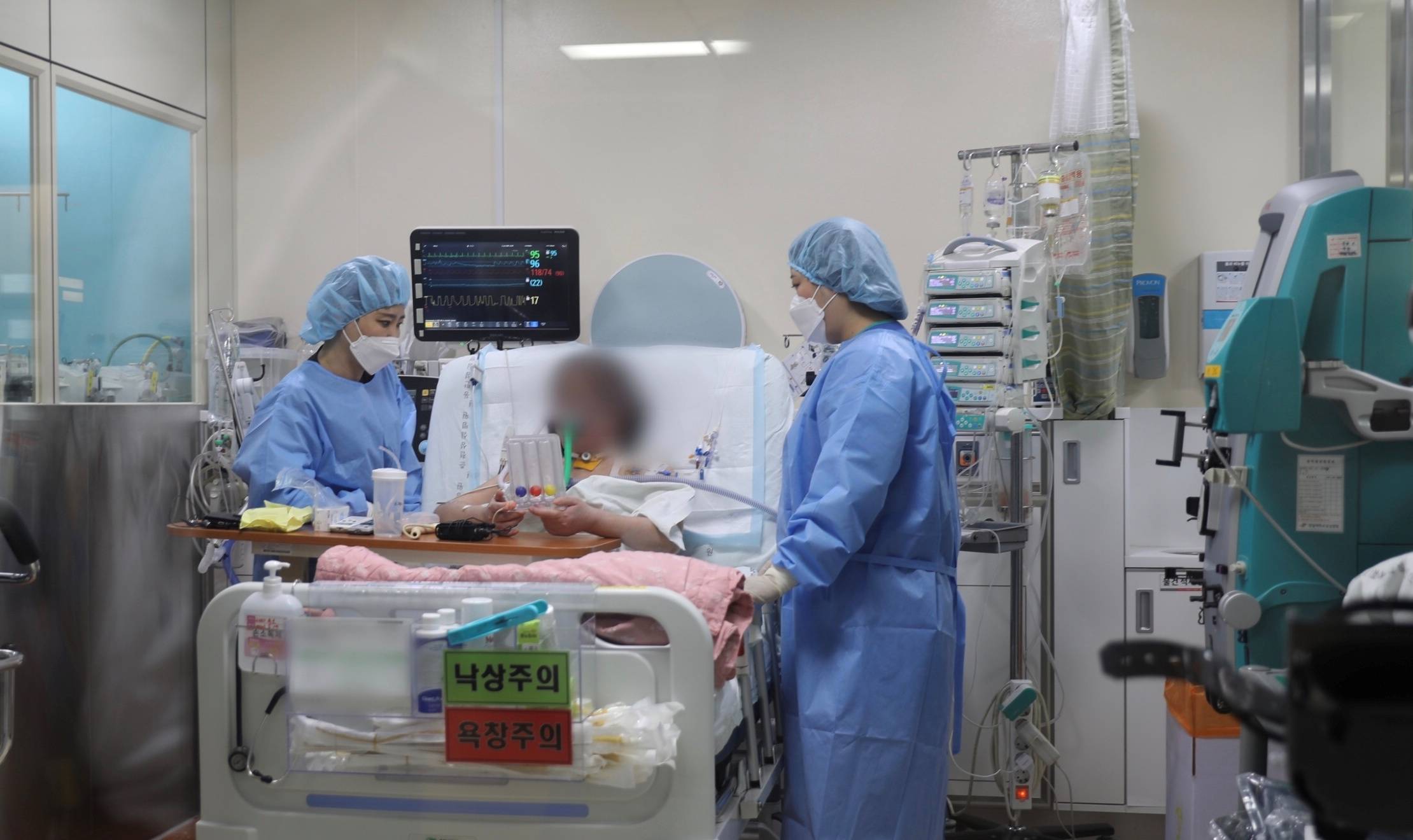 A former coronavirus disease patient who underwent lung transplant surgery, takes a remedial exercise at Hallym Sacred Heart Hospital ECMO Center in Anyang, South Korea, on July 1. | HALLYM SACRED HEART HOSPITAL ECMO CENTER / VIA REUTERS