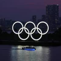 The Olympic rings float in the water at sunset in Tokyo\'s Odaiba waterfront district.  | AP
