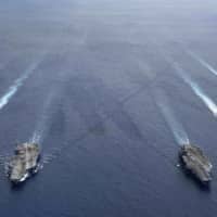 The USS Ronald Reagan and USS Nimitz carrier strike groups steam in formation in the South China Sea on July 6. | U.S. NAVY / VIA AP