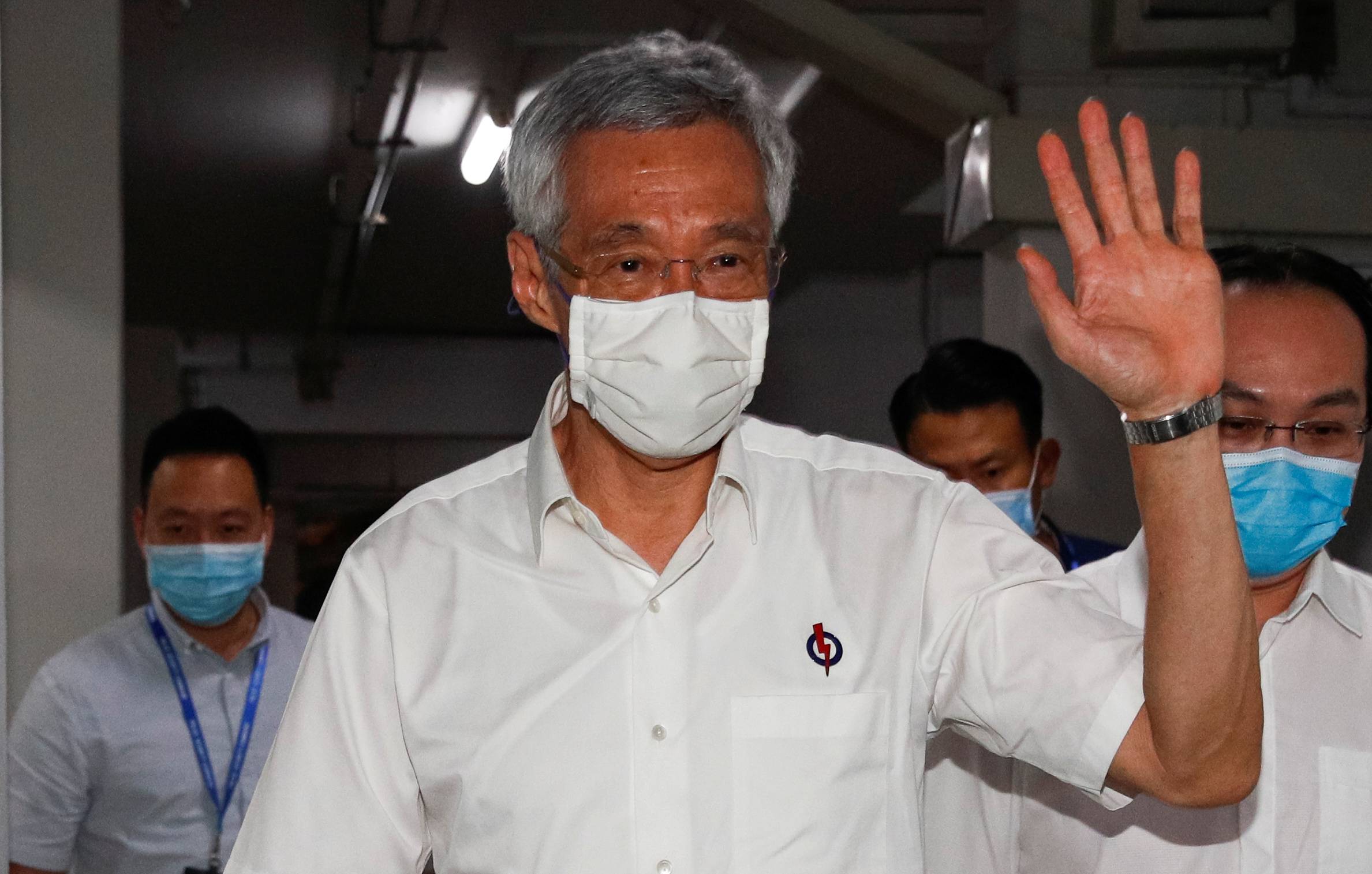 Singapore's Prime Minister Lee Hsien Loong waves as he arrives at a People's Action Party branch office on Saturday. The ruling party won 83 seats — or 89 percent of those up for grabs. | REUTERS