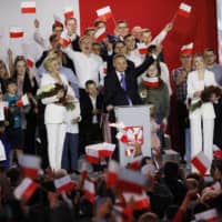Andrzej Duda (center), Poland\'s president and Law & Justice (Pis) candidate, gestures while speaking during an election night rally near Pultusk Castle in Pultusk, Poland, on Sunday. | BLOOMBERG