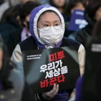 A demonstrator holds a sign that reads \"MeToo, we change the world\" during an International Women\'s Day rally in Seoul on March 8, 2019.  | BLOOMBERG 
