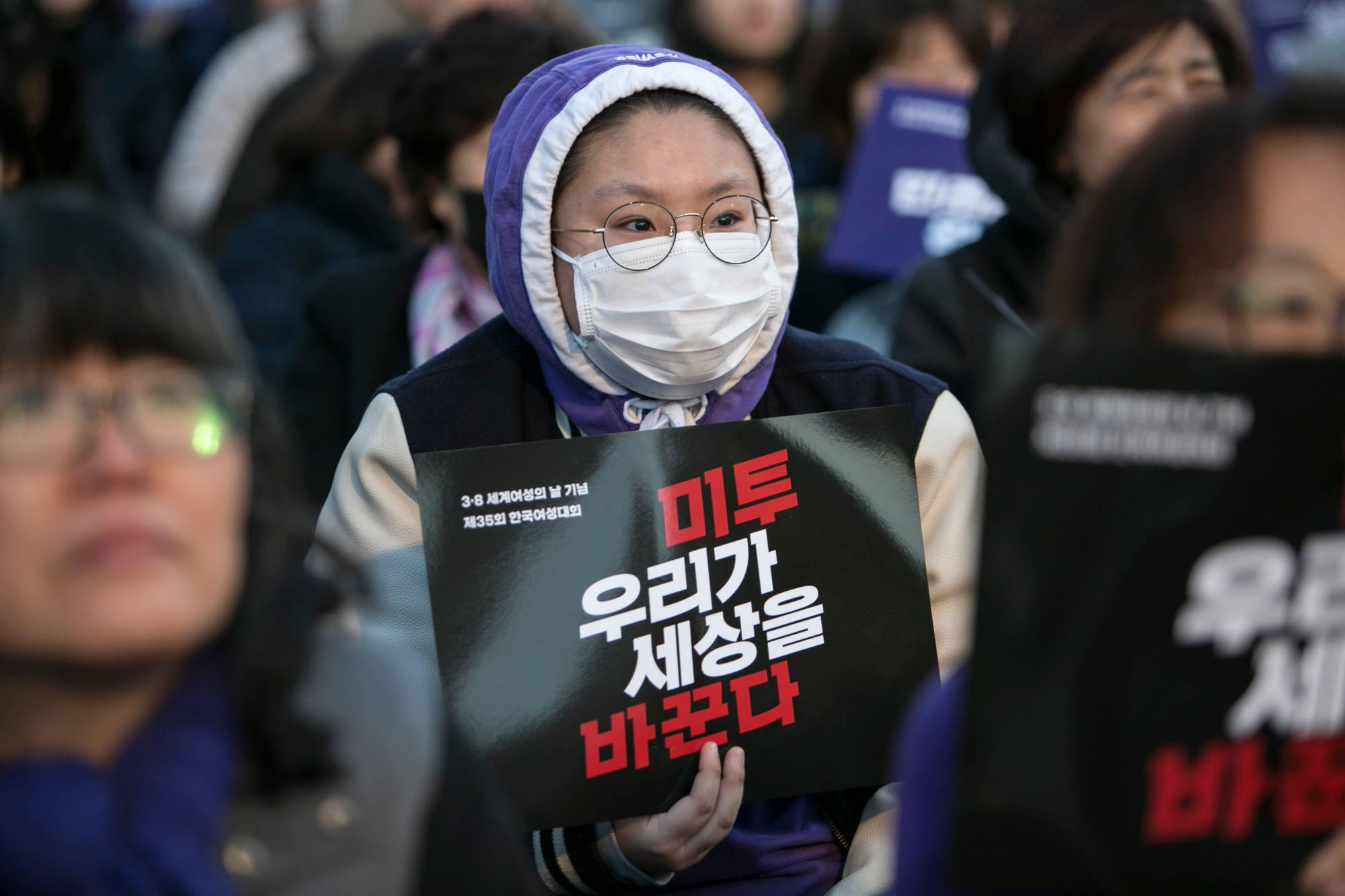 A demonstrator holds a sign that reads 