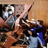 Lawmakers from Taiwan\'s ruling Democratic Progressive Party scuffle with lawmakers from the main opposition Kuomintang party, who have been occupying the Legislature Yuan, in Taipei. | REUTERS