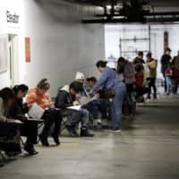People who worked in the hospitality industry apply for unemployment benefits in Los Angeles.  | AP