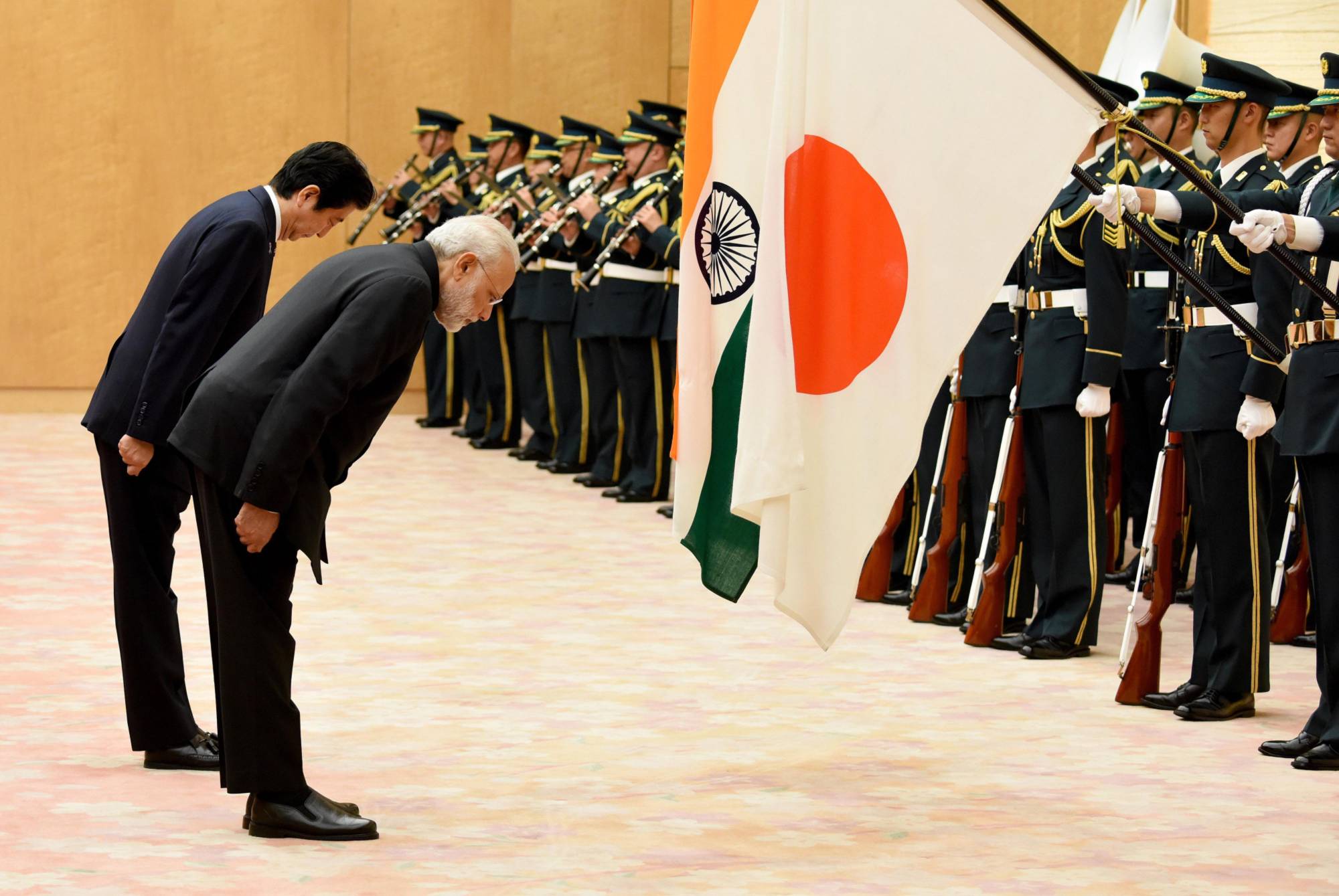 Prime Minister Shinzo Abe, seen here reviewing an honor guard in Tokyo with Indian Prime Minister Narendra Modi in November 2016, has been seeking to build a consensus to counter an increasingly aggressive China. | BLOOMBERG