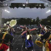 Dancers perform during a drive-in concert at Gyeongbok Palace parking lot in Seoul on Friday. Older children are more likely to spread COVID-19 within a household than younger children and adults, according to a new study of 5,706 coronavirus patients in South Korea. | AP