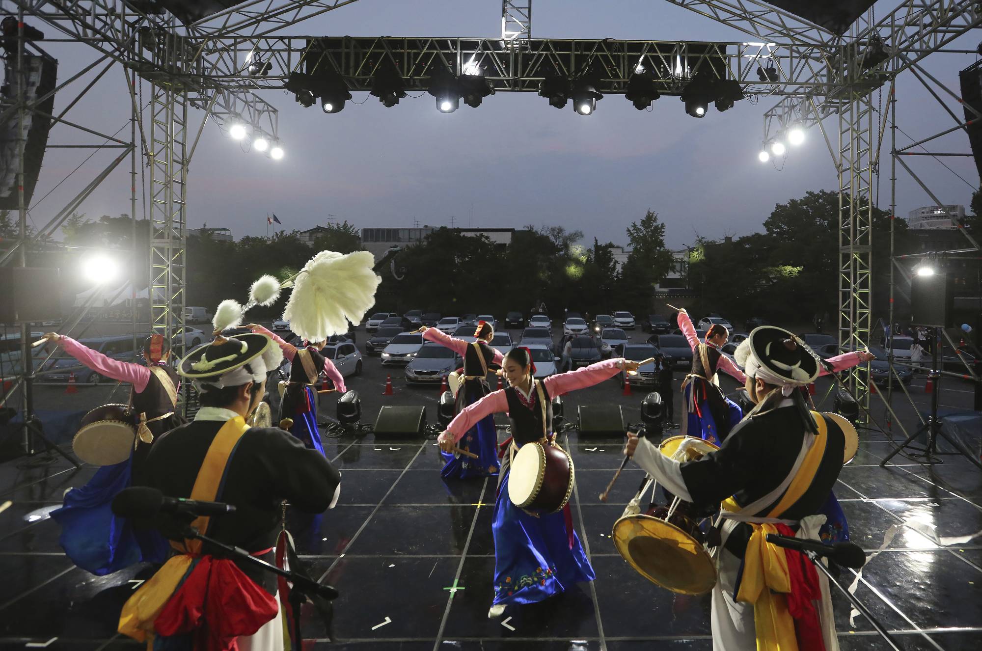 Dancers perform during a drive-in concert at Gyeongbok Palace parking lot in Seoul on Friday. Older children are more likely to spread COVID-19 within a household than younger children and adults, according to a new study of 5,706 coronavirus patients in South Korea. | AP
