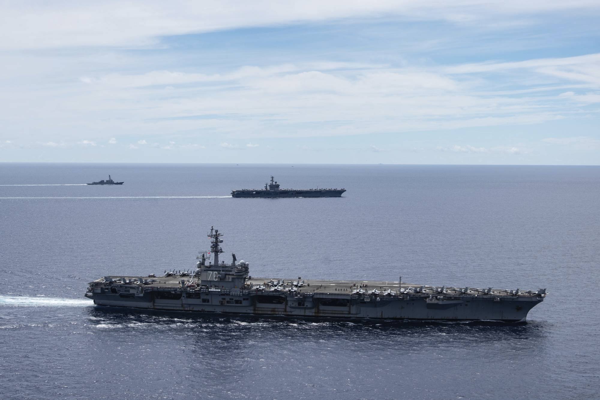 The USS Ronald Reagan (front) and USS Nimitz Carrier Strike Groups sail together in formation in the disputed South China Sea on July 6. | U.S. NAVY / VIA AP