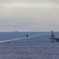Maritime Self-Defense Force training ships Kashima and Shimayuki conduct a passing exercise with the USS Ronald Reagan aircraft carrier in the South China Sea on July 7.  | U.S. NAVY VIA REUTERS